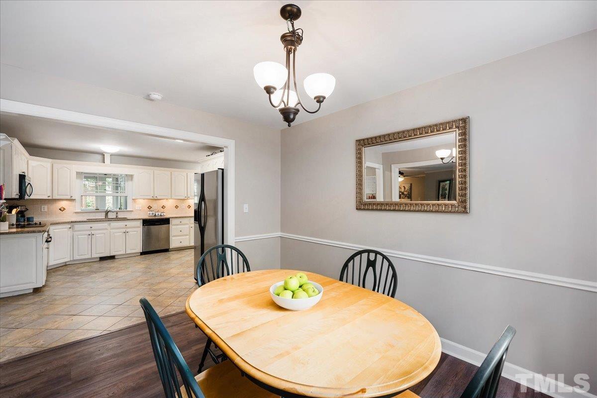 1313 Falls Church Road Raleigh, NC 27609 - Photo 17 of 40 a view of a dining room with furniture and wooden floor