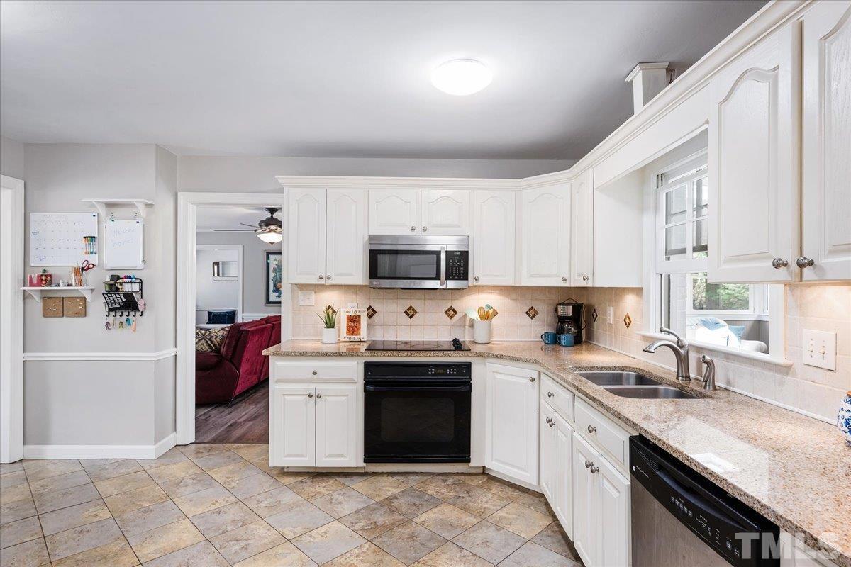 1313 Falls Church Road Raleigh, NC 27609 - Photo 20 of 40 a kitchen with a sink a stove and cabinets