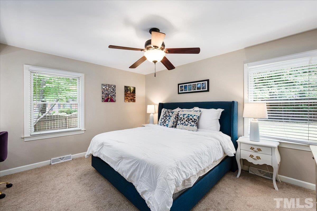 1313 Falls Church Road Raleigh, NC 27609 - Photo 23 of 40 a bedroom with a bed and a chandelier