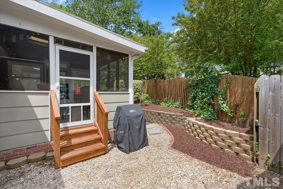 1313 Falls Church Road Raleigh, NC 27609 - Photo 36 of 40 a view of a backyard with a large tree and wooden fence