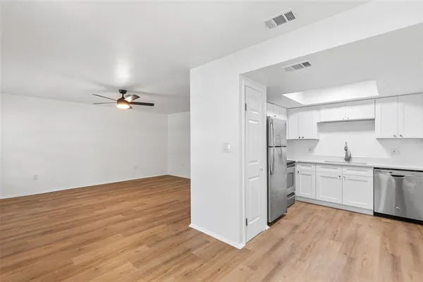 a kitchen with a refrigerator and white cabinets