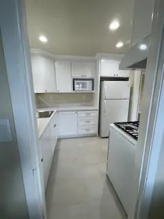a kitchen with white cabinets and white appliances