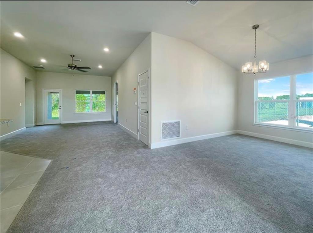 7592 Bent Tree Loop St. Cloud, FL 34773 - Photo 3 of 12 a view of an empty room with windows and chandelier
