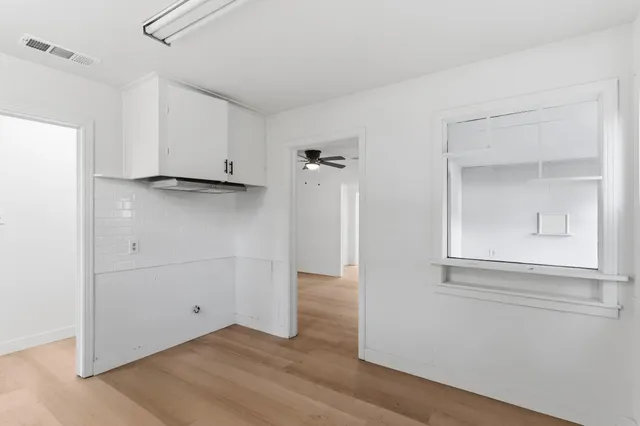 an empty room with wooden floor and a window