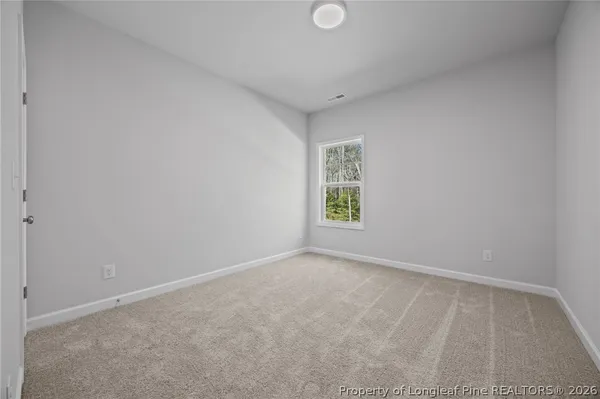 a view of empty room with wooden floor and window