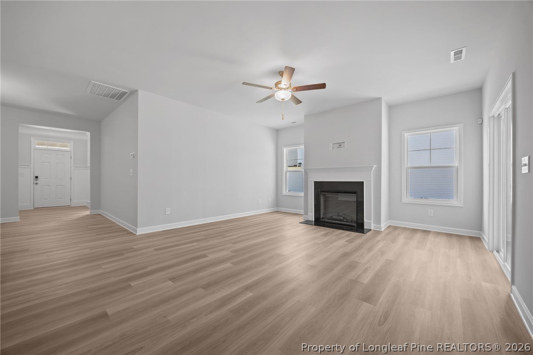 151 Michter Street Vass, NC 28394 - Photo 22 of 47 a view of a livingroom with wooden floor and a ceiling fan