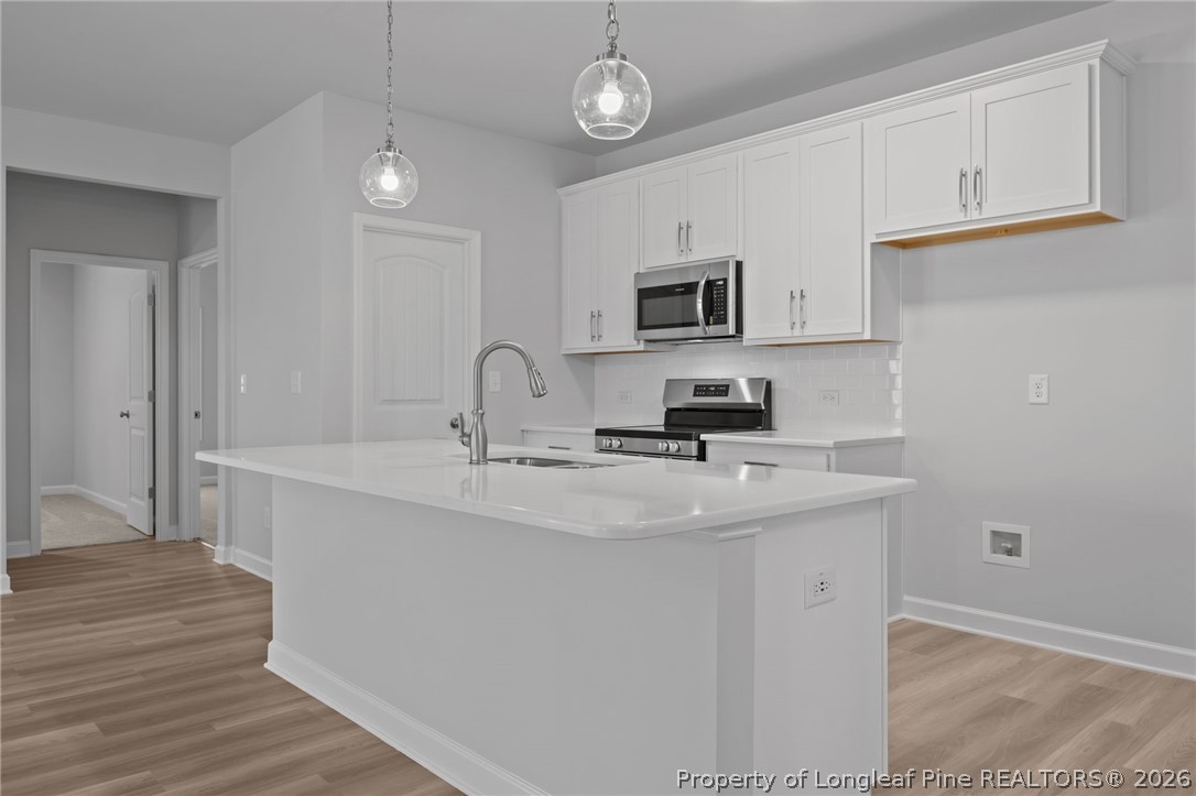 151 Michter Street Vass, NC 28394 - Photo 27 of 47 a kitchen with stainless steel appliances a sink a stove a refrigerator and cabinets