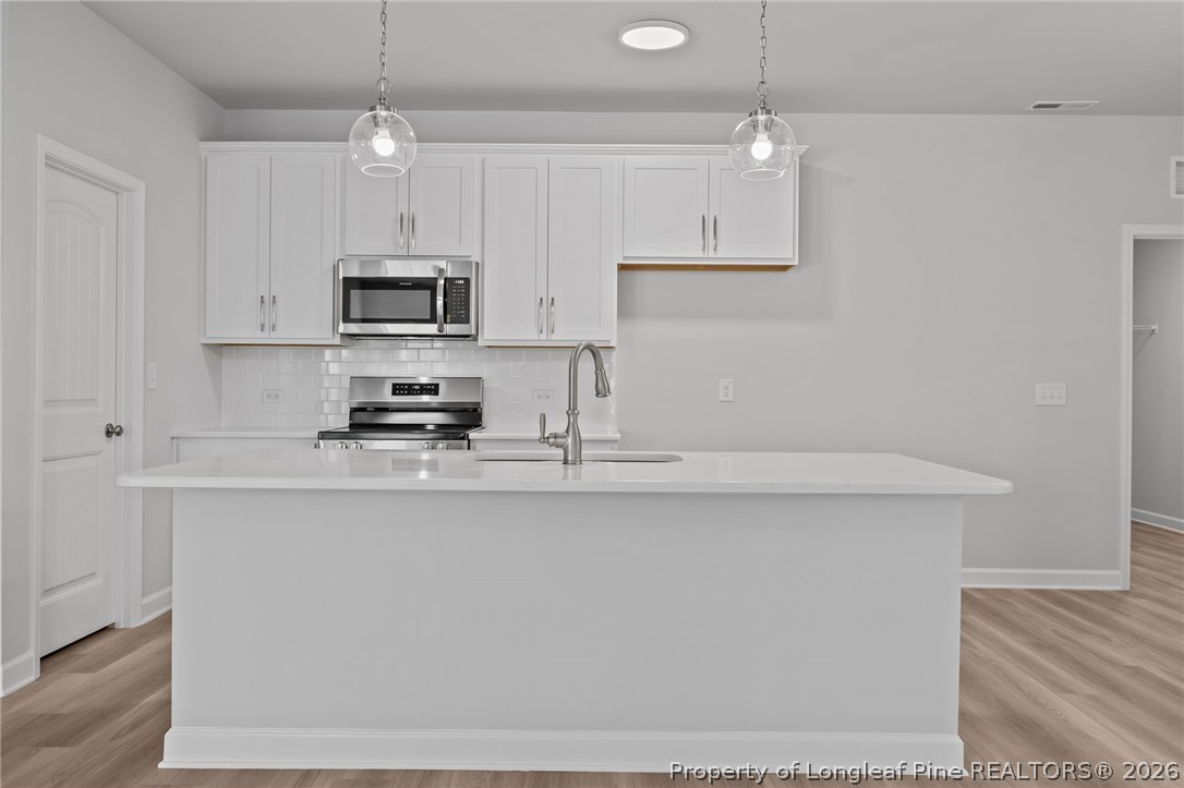 151 Michter Street Vass, NC 28394 - Photo 28 of 47 a kitchen with stainless steel appliances a microwave a sink and a refrigerator