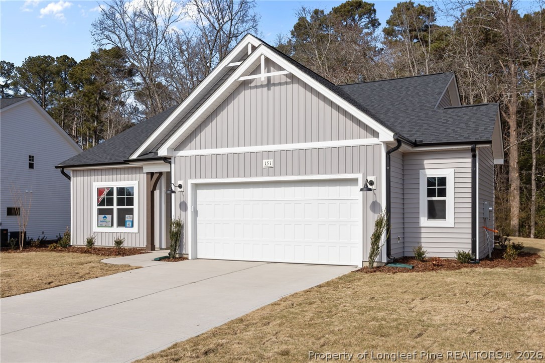 151 Michter Street Vass, NC 28394 - Photo 3 of 47 a front view of a house with a yard and garage