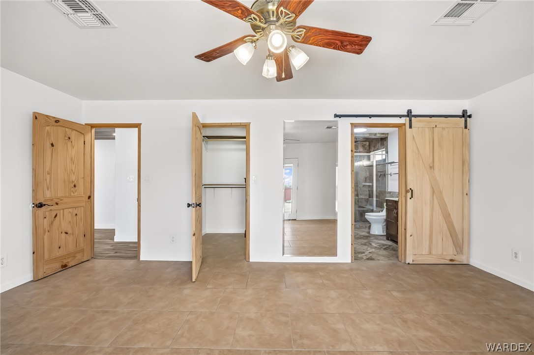4088 Mercer Road Bullhead City, AZ 86429 - Photo 15 of 35 Spacious room featuring tile flooring, a ceiling fan with light fixture, and white walls