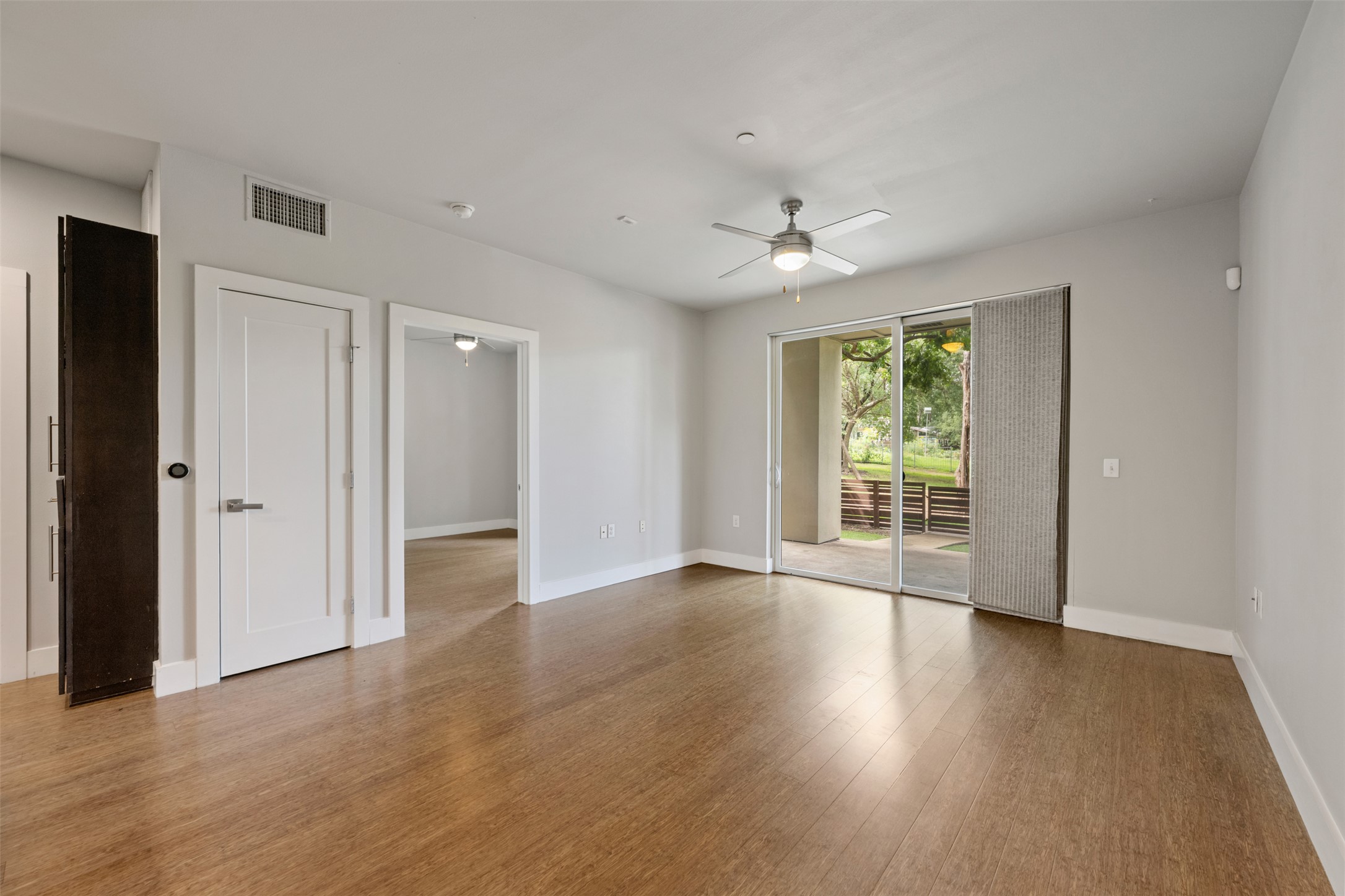 2804 Treble Lane, Unit 902 Austin, TX 78704 - Photo 14 of 31 a view of an empty room with wooden floor and a window