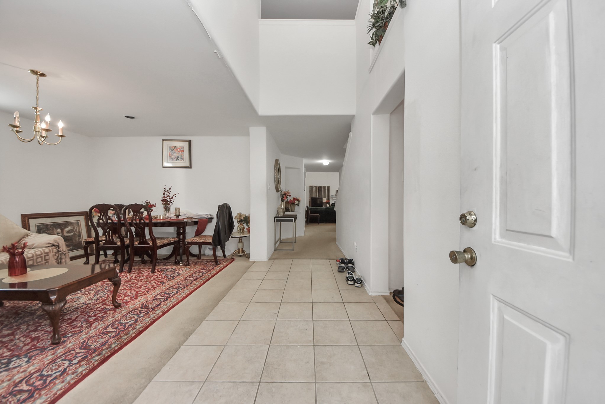 10003 Dakota Ridge Court Houston, TX 77095 - Photo 4 of 30 a hallway with dining area and chandelier