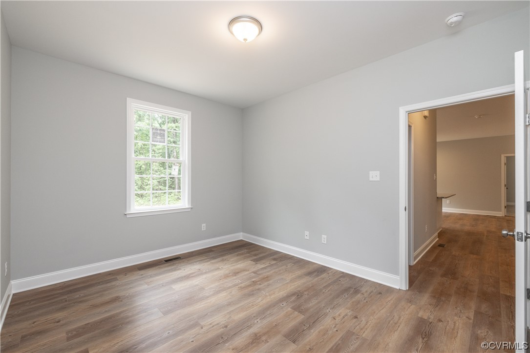 76 Trents Mill Road Cumberland, VA 23040 - Photo 24 of 36 an empty room with wooden floor and windows
