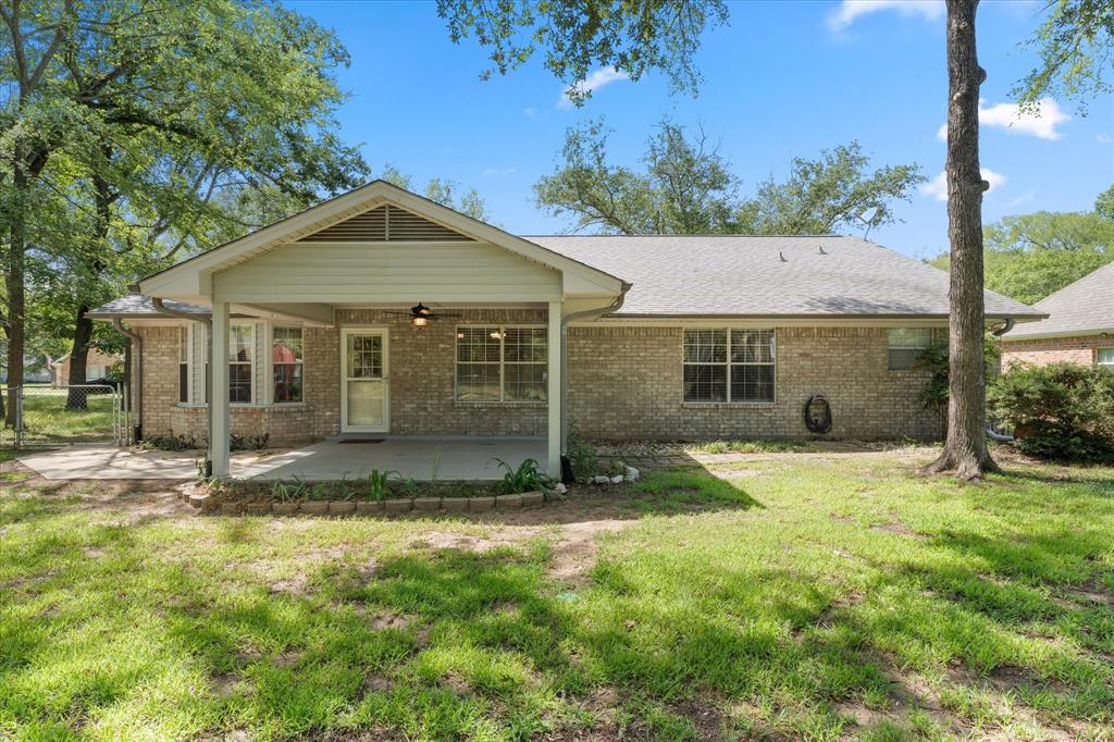 116 Meadowood Road Enchanted Oaks, TX 75156 - Photo 5 of 37 Brick exterior home featuring a covered patio, additional concrete patio area, and mature trees