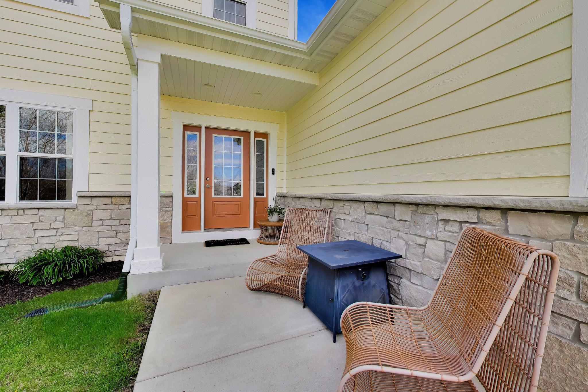 N2392 Mildred Street Delavan, WI 53115 - Photo 3 of 41 Welcoming covered front porch with stone-accented pillars and natural wood-tone front door.
