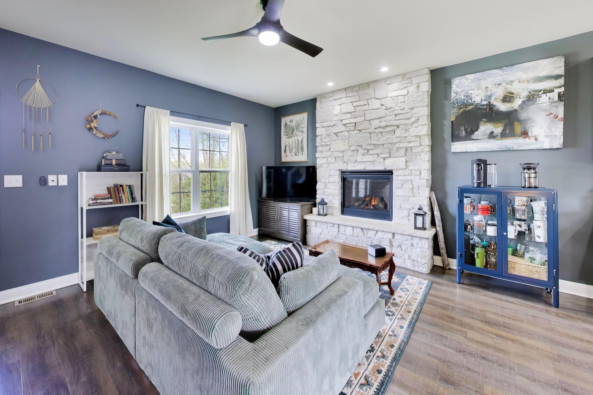 N2392 Mildred Street Delavan, WI 53115 - Photo 5 of 41 Living room highlights a floor-to-ceiling stone gas fireplace with a raised stone hearth.
