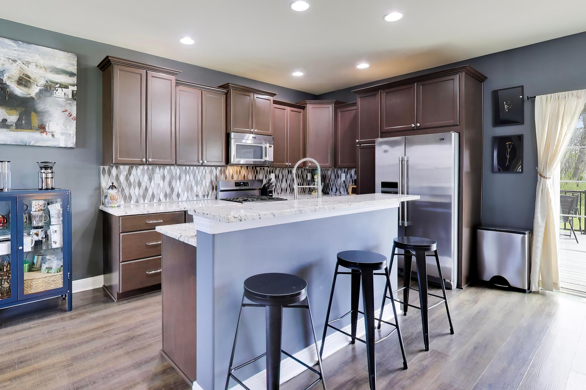 N2392 Mildred Street Delavan, WI 53115 - Photo 6 of 41 Modern kitchen with granite countertops, maple cabinetry, and a granite countered breakfast bar.