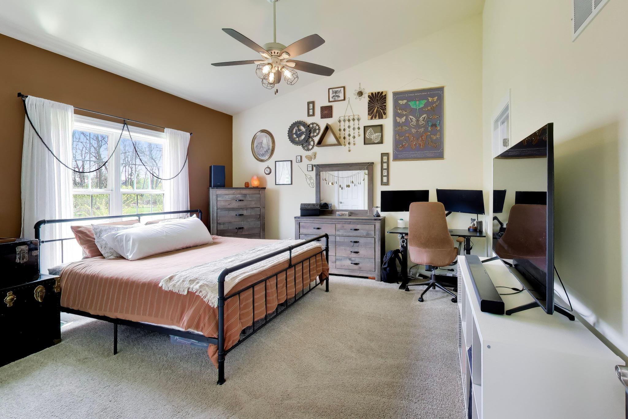 N2392 Mildred Street Delavan, WI 53115 - Photo 9 of 41 Main-level primary bedroom featuring vaulted ceilings and a cooling ceiling fan.