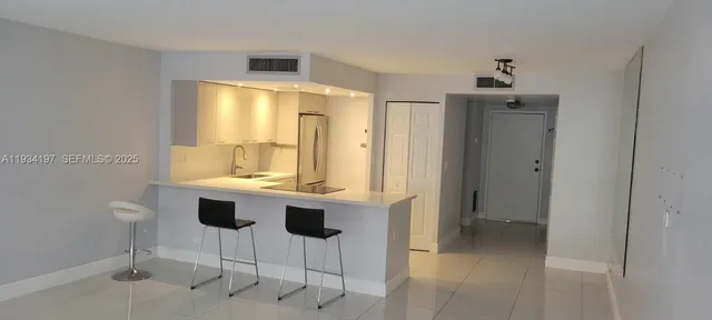 a view of kitchen with a sink wooden cabinets and glass door