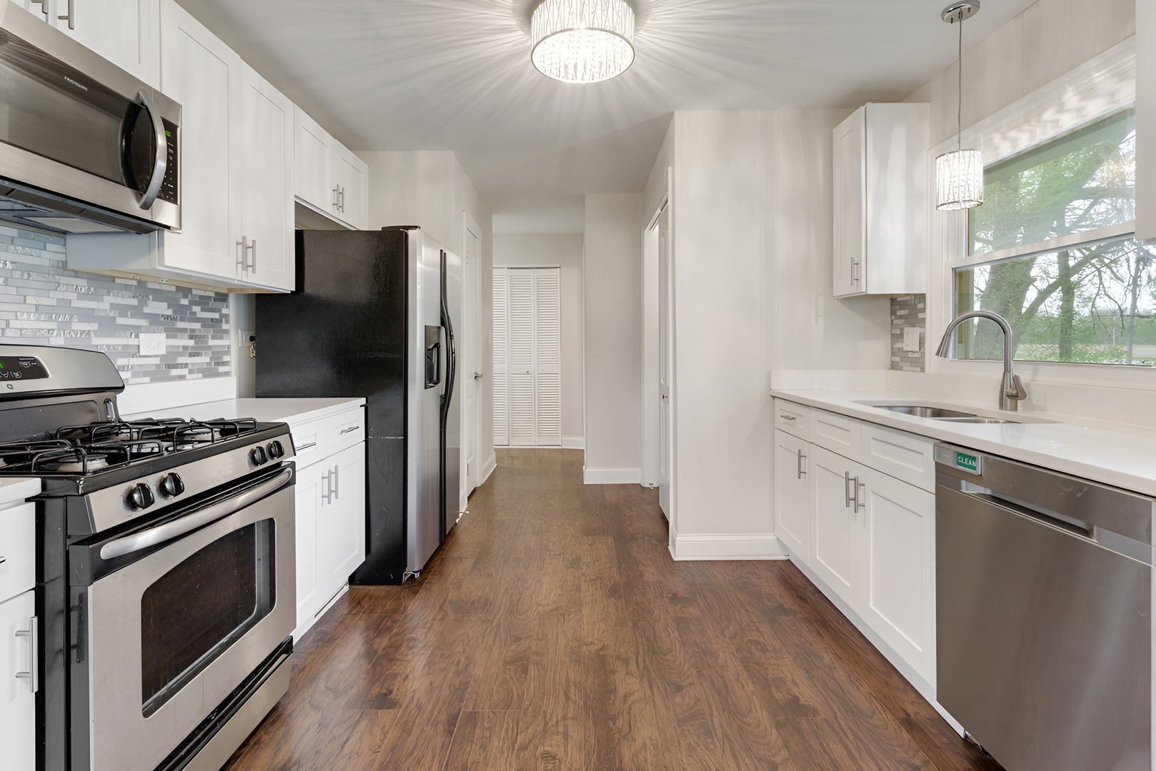 15303 Birch Road Markham, IL 60428 - Photo 11 of 20 a kitchen with a stove a sink and a microwave