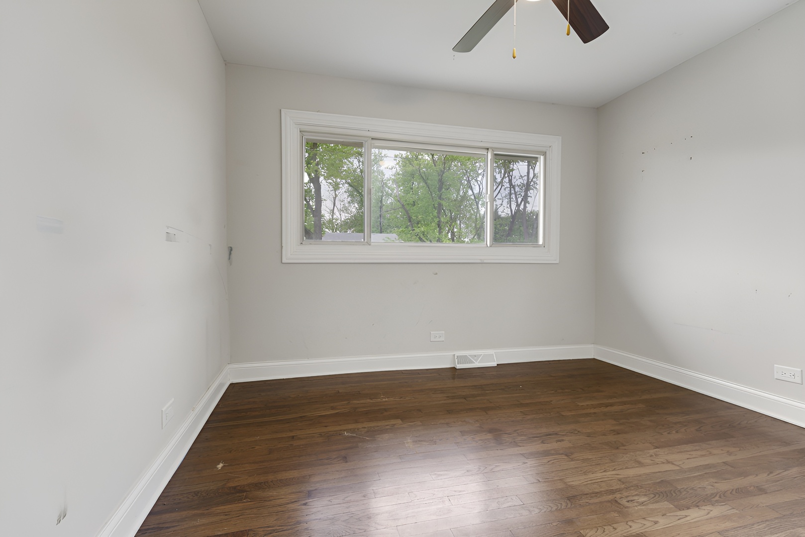 15303 Birch Road Markham, IL 60428 - Photo 13 of 20 an empty room with wooden floor and windows
