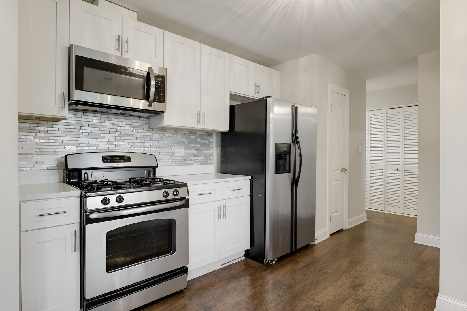 15303 Birch Road Markham, IL 60428 - Photo 9 of 20 a kitchen with stainless steel appliances white cabinets a stove top oven a refrigerator with a sink and dishwasher