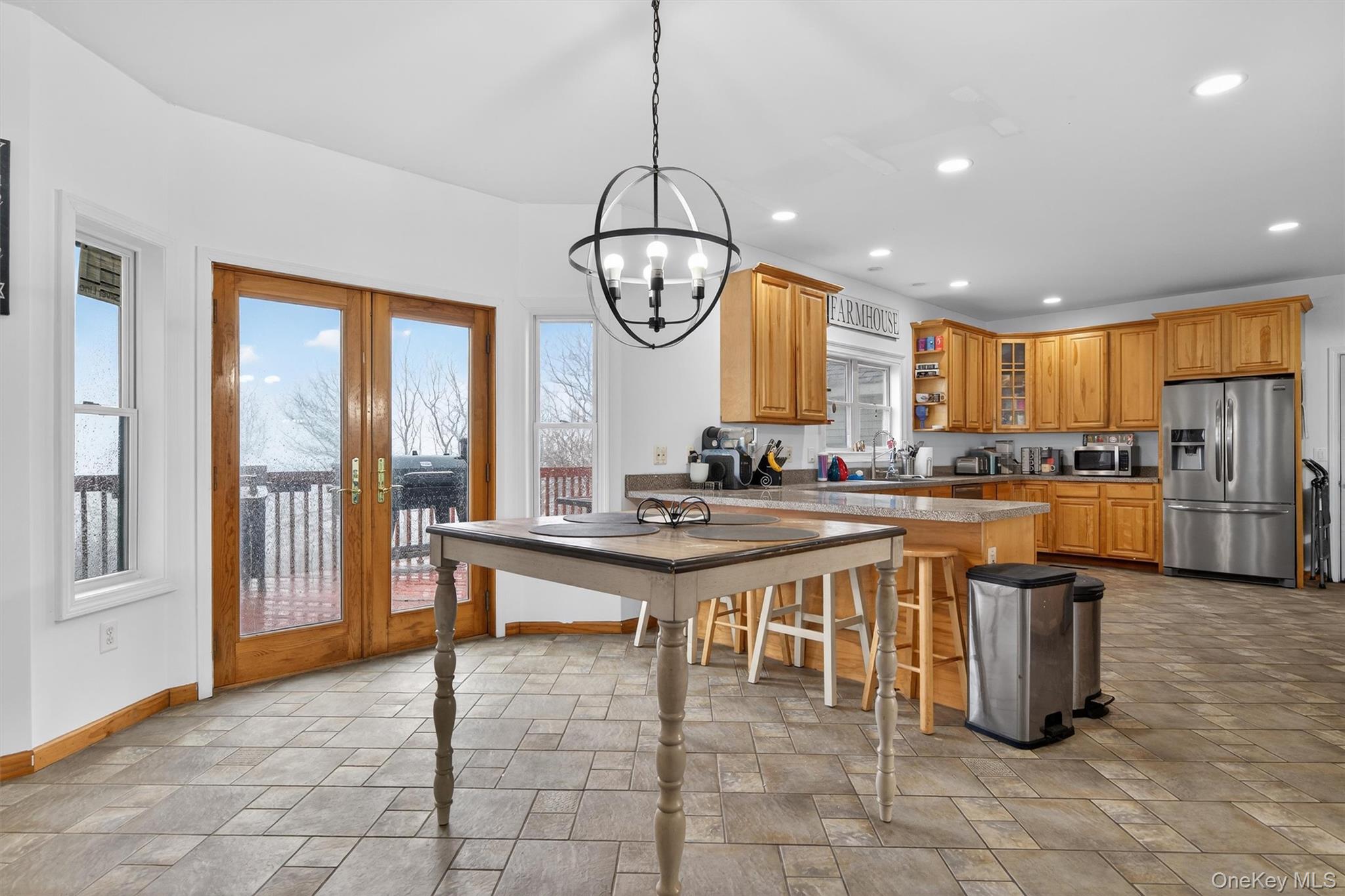 71 Eagle Crest Road Port Jervis, NY 12771 - Photo 15 of 45 Kitchen featuring light stone finish floors, a peninsula, french doors, open shelves, and stainless steel appliances