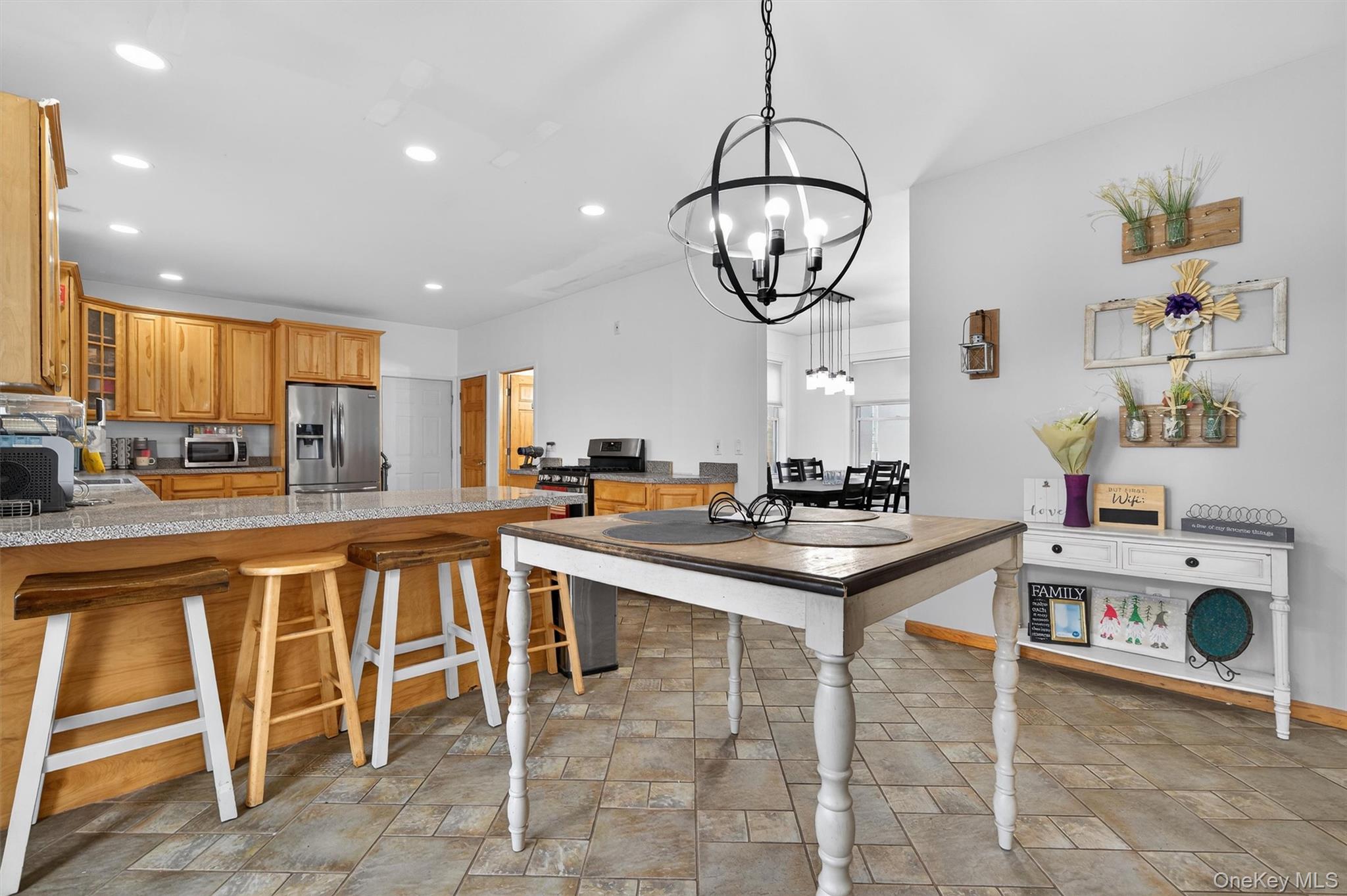 71 Eagle Crest Road Port Jervis, NY 12771 - Photo 16 of 45 Kitchen with glass fronted cabinets, a kitchen bar, a peninsula, stainless steel appliances, and stone finish floors