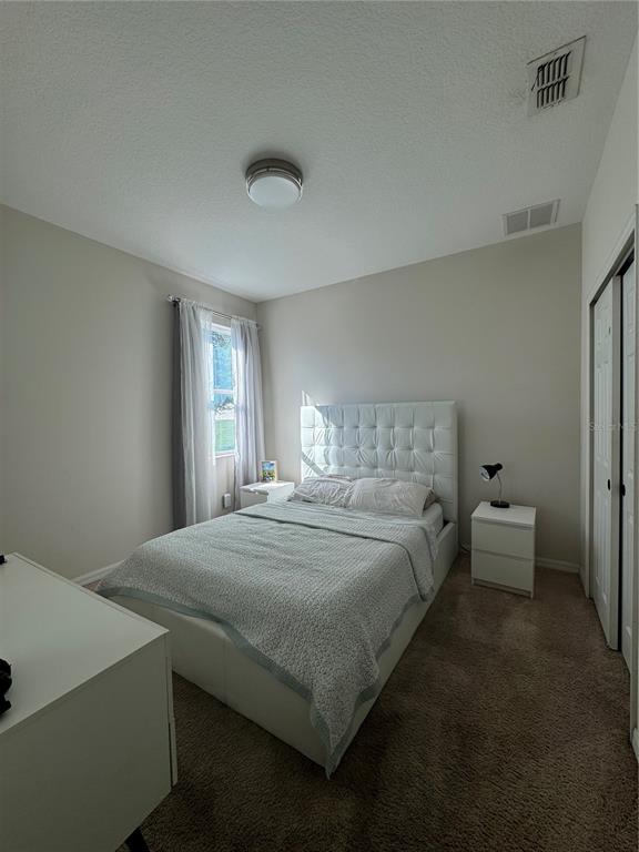 14645 Magnolia Ridge Loop Winter Garden, FL 34787 - Photo 12 of 20 a bedroom with a bed and a window