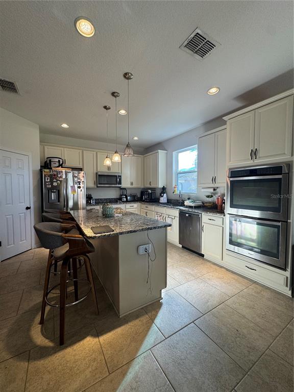 14645 Magnolia Ridge Loop Winter Garden, FL 34787 - Photo 6 of 20 a kitchen with stainless steel appliances kitchen island granite countertop a stove sink and cabinets