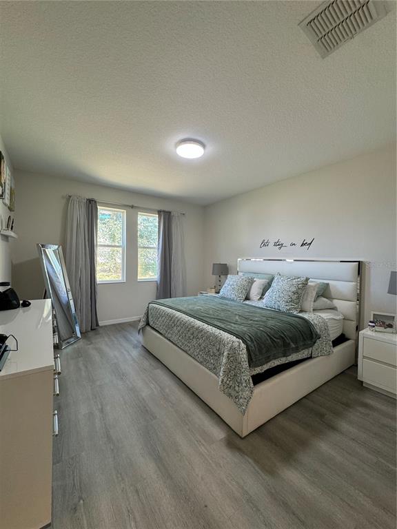 14645 Magnolia Ridge Loop Winter Garden, FL 34787 - Photo 8 of 20 a bedroom with a large bed and a window