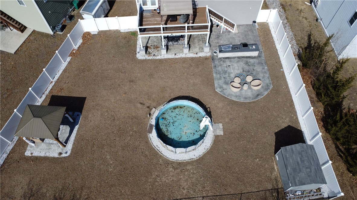 32 Dike Street Woonsocket, RI 02895 - Photo 14 of 20 Beautifully fenced backyard featuring a stone patio, shed, outdoor kitchen, gazebo, above-ground pool, and more, perfect for entertaining and enjoying outdoor living.