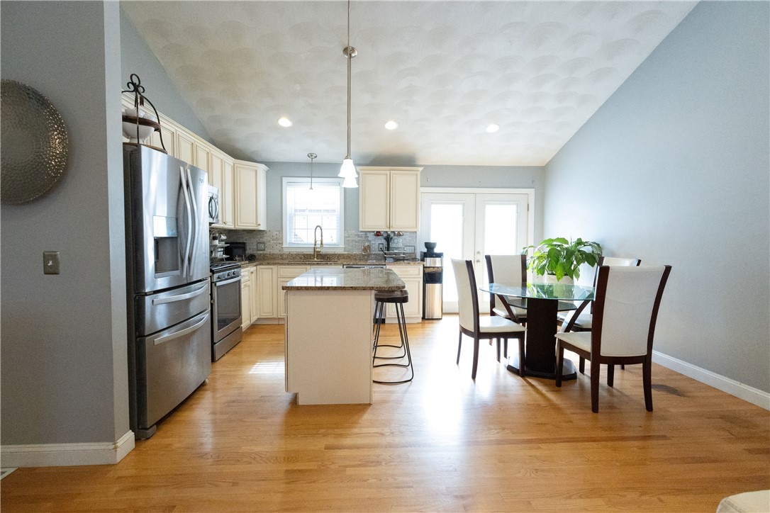 32 Dike Street Woonsocket, RI 02895 - Photo 19 of 20 The open floor plan offers a spacious living room and dining area with double doors leading to a large deck, ideal for indoor-outdoor living.