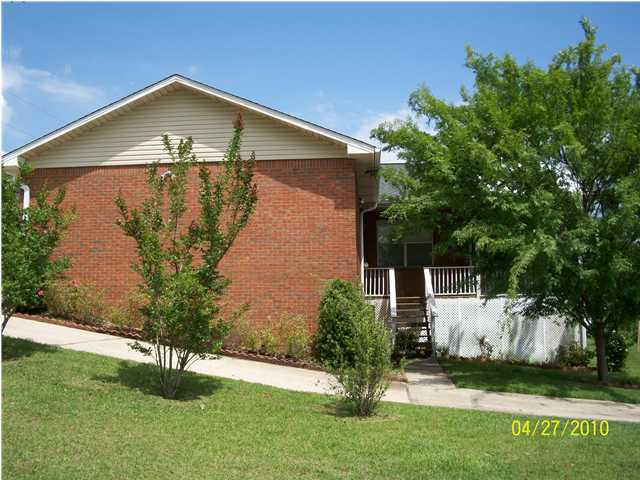 1584 Spring Lake Road DeFuniak Springs, FL 32433 - Photo 1 of 19 a front view of a house with a yard