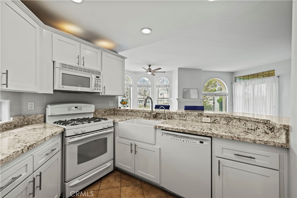25518 Hemingway Avenue, Unit A Stevenson Ranch, CA 91381 - Photo 15 of 54 a kitchen with granite countertop white cabinets white stainless steel appliances with a sink and dishwasher