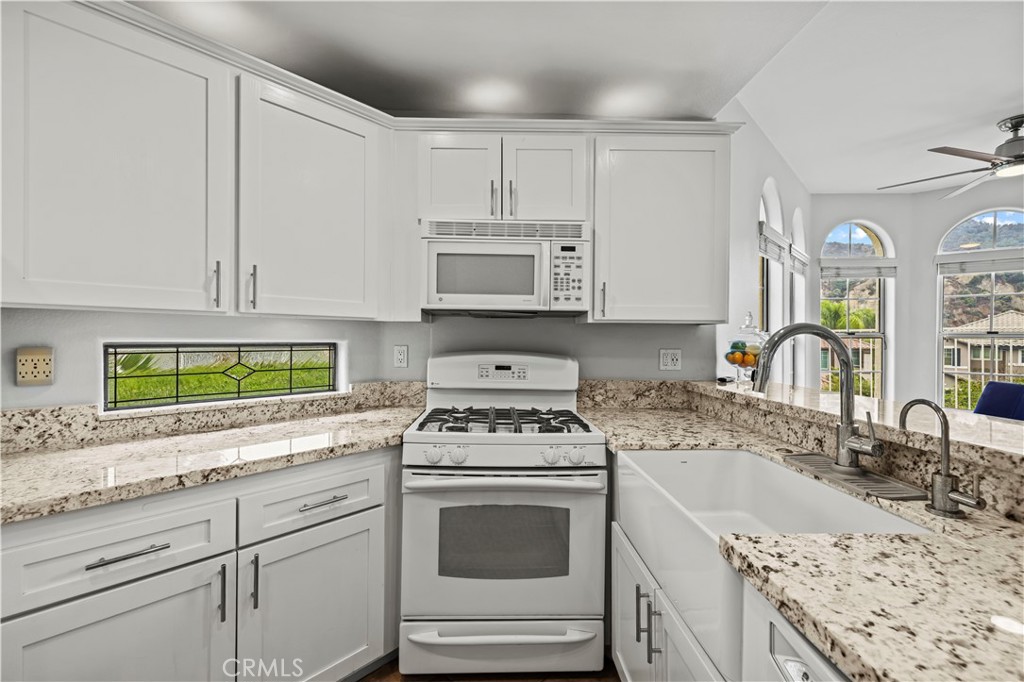 25518 Hemingway Avenue, Unit A Stevenson Ranch, CA 91381 - Photo 16 of 54 a kitchen with granite countertop a stove sink and cabinets