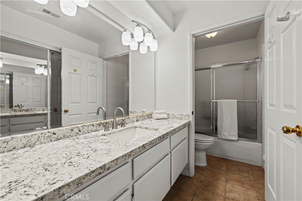 25518 Hemingway Avenue, Unit A Stevenson Ranch, CA 91381 - Photo 26 of 54 a bathroom with a granite countertop sink a toilet a large mirror and shower