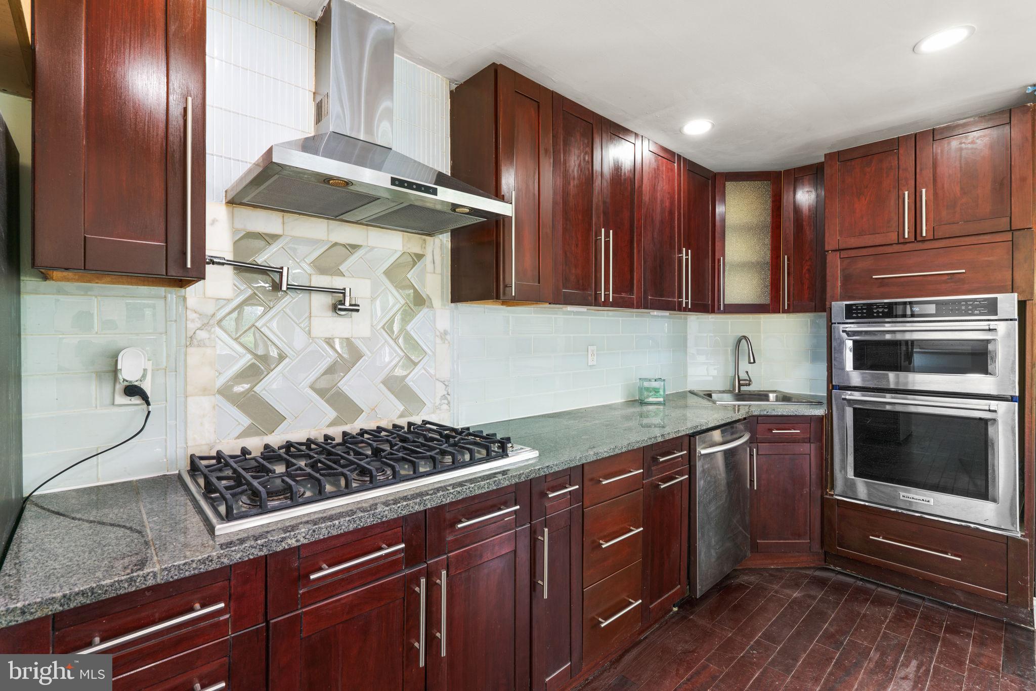 800 North Point Road Baltimore, MD 21224 - Photo 12 of 40 a kitchen with stainless steel appliances granite countertop wooden cabinets stove top oven and sink