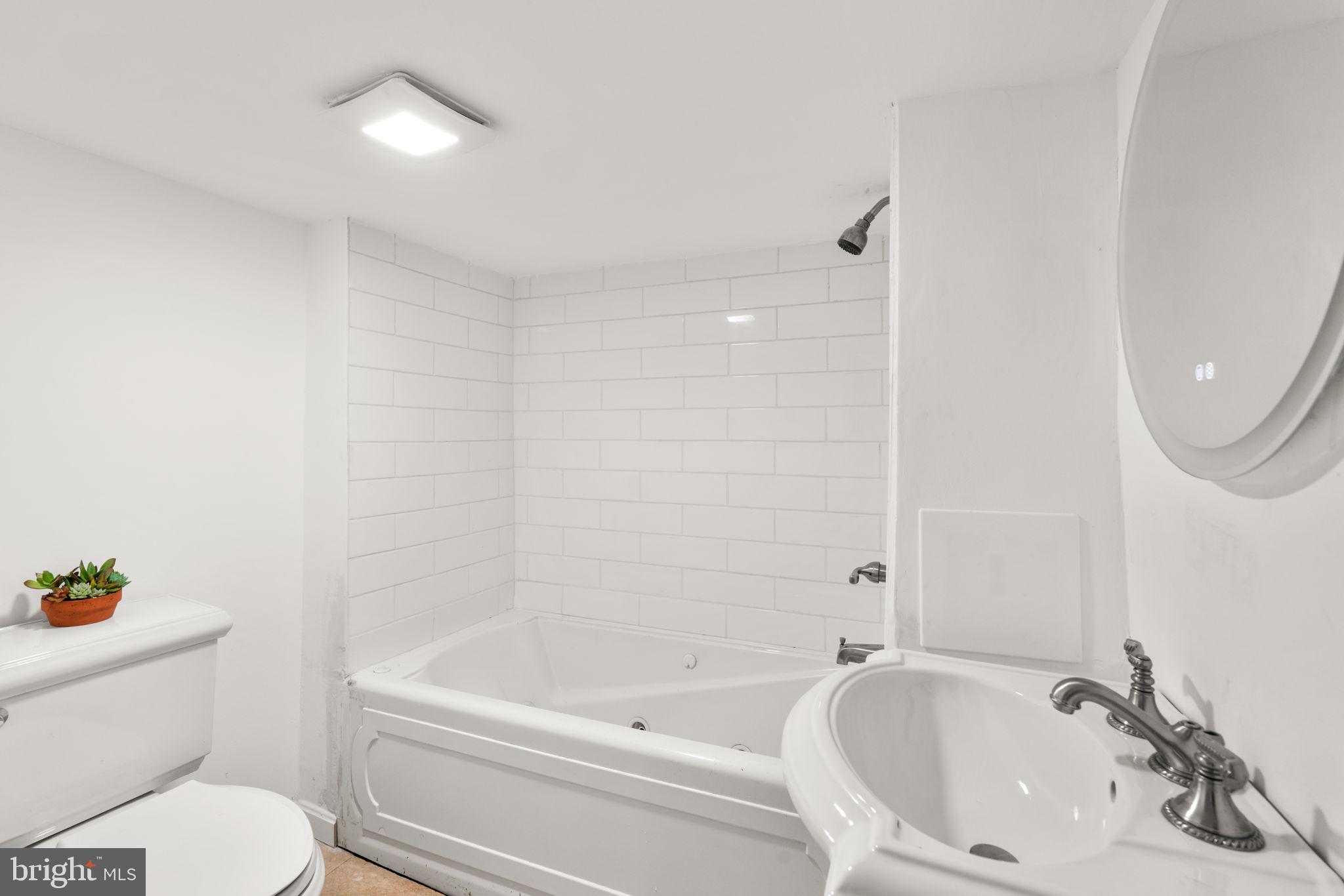 800 North Point Road Baltimore, MD 21224 - Photo 29 of 40 a bathroom with a bathtub shower sink vanity and toilet