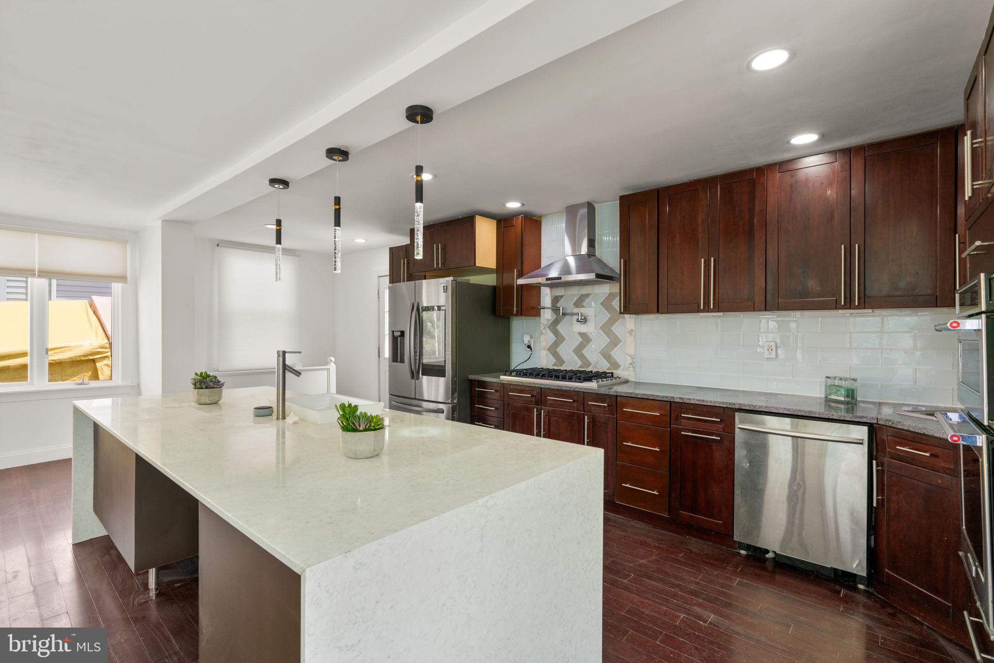 800 North Point Road Baltimore, MD 21224 - Photo 10 of 40 a kitchen with kitchen island granite countertop a sink cabinets and wooden floor