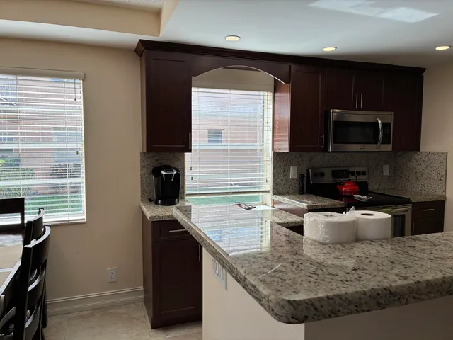 a kitchen with stainless steel appliances granite countertop a sink stove microwave and cabinets