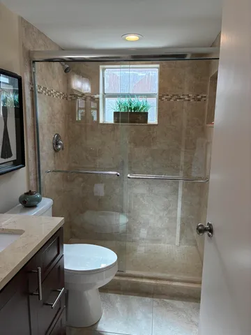 a bathroom with a sink a toilet and shower