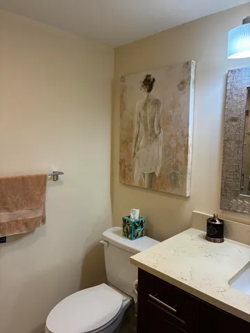 a bathroom with a granite countertop sink a toilet and a mirror