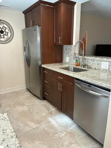 a kitchen with stainless steel appliances granite countertop a refrigerator and a sink