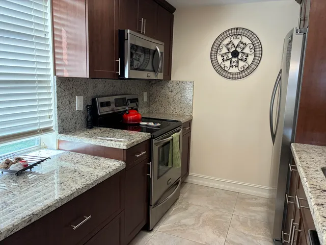 a kitchen with stainless steel appliances granite countertop a stove and a microwave