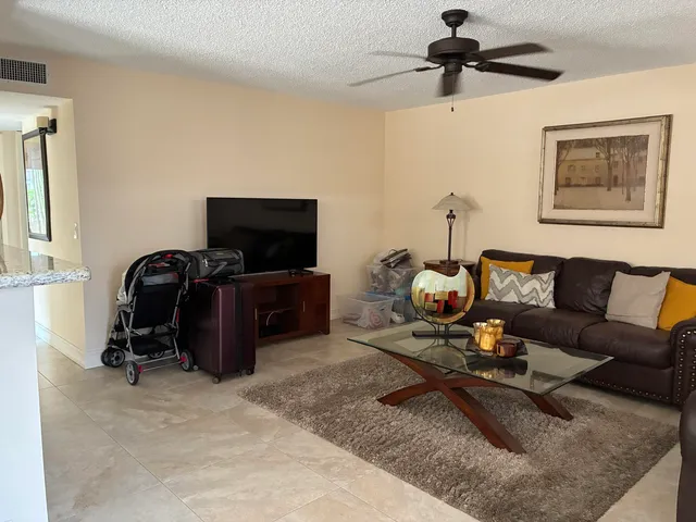 a living room with furniture a ceiling fan and a rug