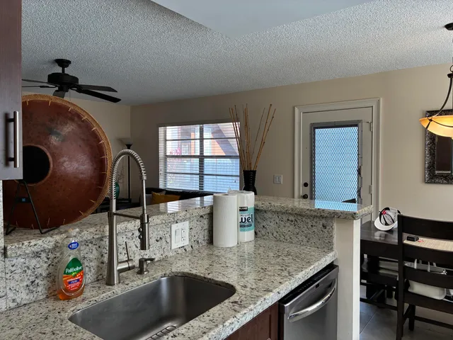 a kitchen with a granite countertop sink a stove and a wooden floors