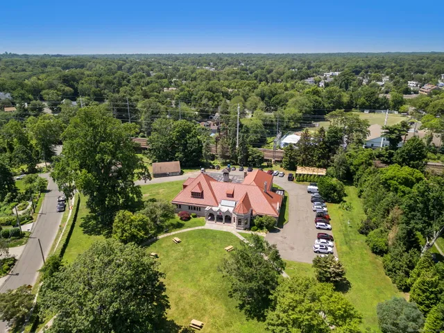 an aerial view of residential house with outdoor space and trees all around