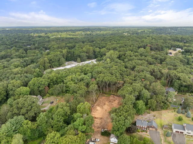 an aerial view of a houses with outdoor space and trees