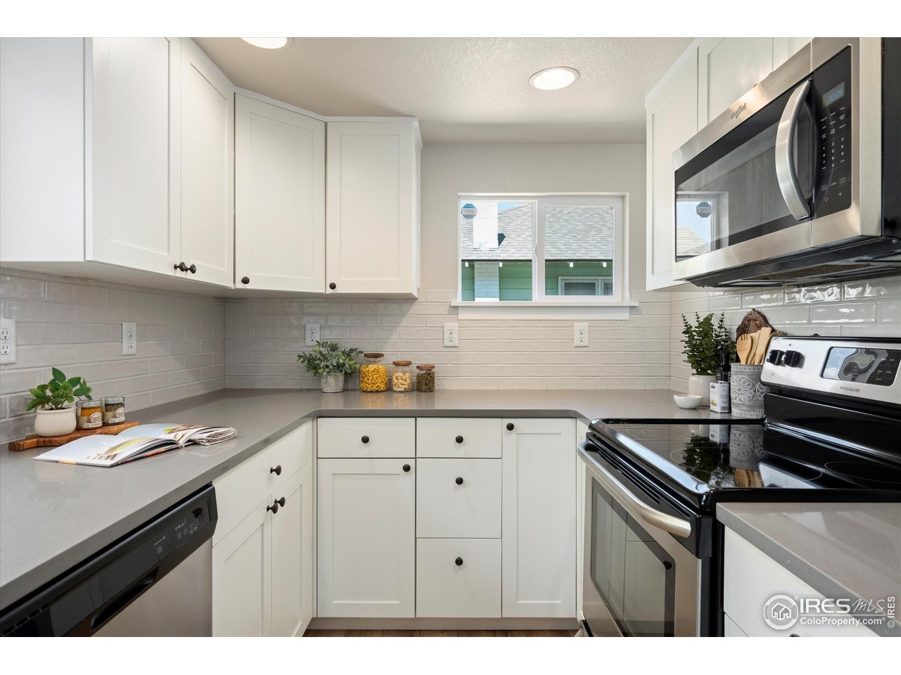 217 Locust Street Windsor, CO 80550 - Photo 11 of 40 a kitchen with stainless steel appliances granite countertop a sink stove and cabinets